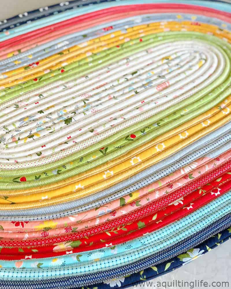 Jelly Roll Rug pattern in Clover Hollow Fabrics featured by top US quilting blog, A Quilting Life: image of jelly roll rug close up