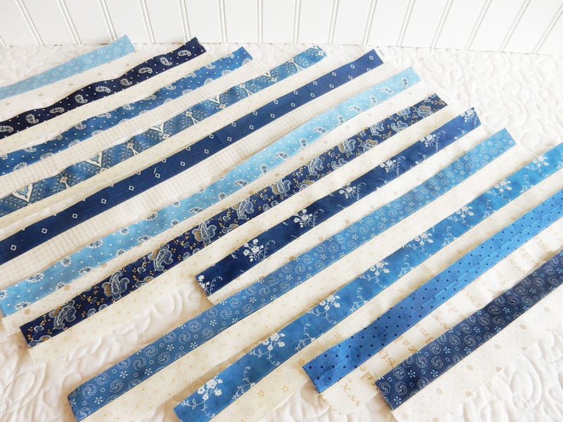 Tips for Pressing Quilt Strip Sets featured by top US quilting blog, A Quilting Life: image of Blue and Cream Strip Sets