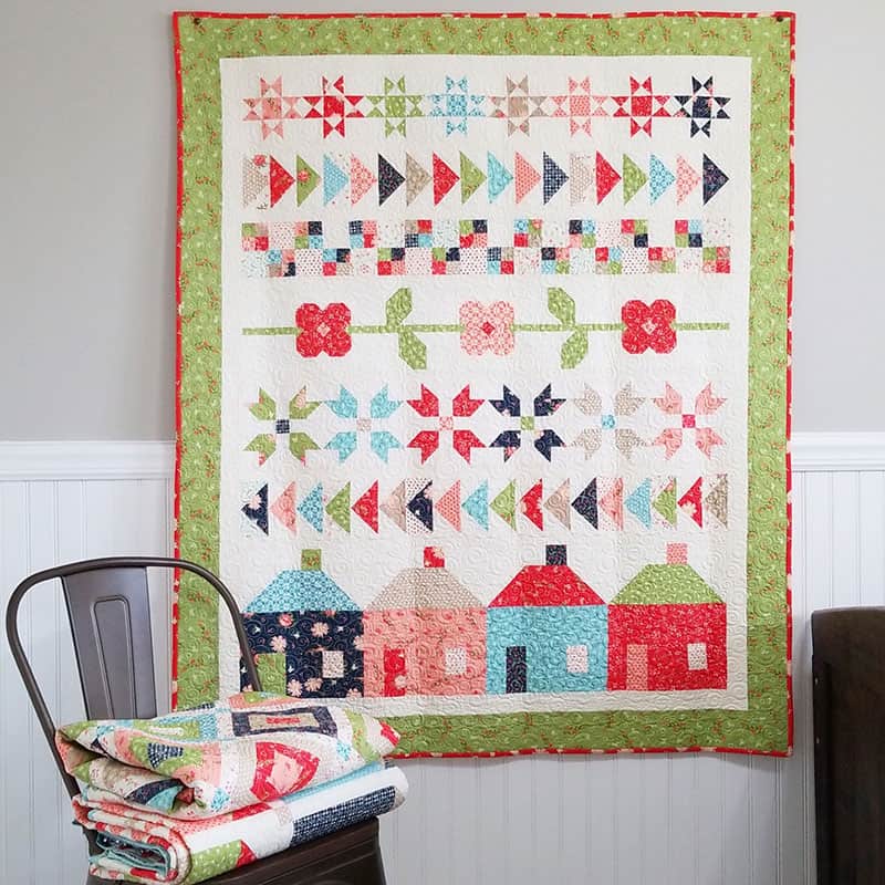 Family Farm Quilt with quilt stack.