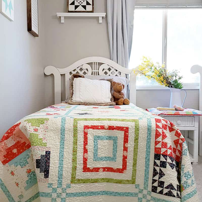 Sunday Best Sampler Quilt by popular quilting blog, A Quilting Life: image of a sampler quilt on a twin size bed.