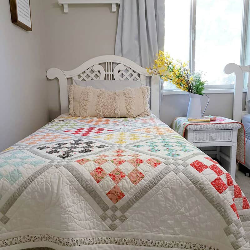 Patchwork Garden 2 | Jelly Roll Quilt Pattern by popular quilting blog, A Quilting Life: image of a Patchwork Garden 2 quilt on a twin size bed.