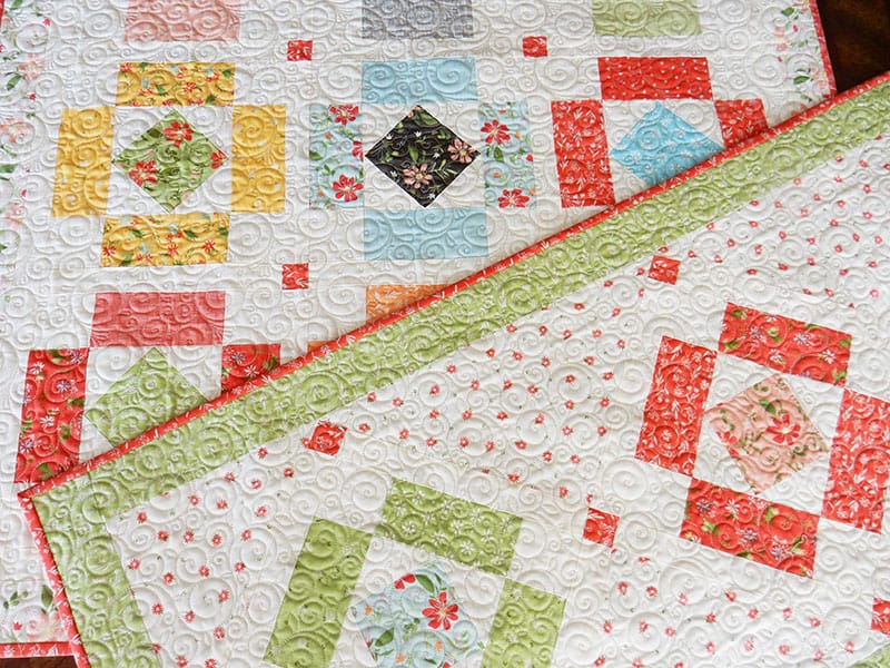 Simply Charming Table Runner & Topper | Simply Charming Charm Pack Runner & Table Topper Quilt Pattern by popular US quilting blog, A Quilting Life: image of a finished Simply Charming table runner and topper.