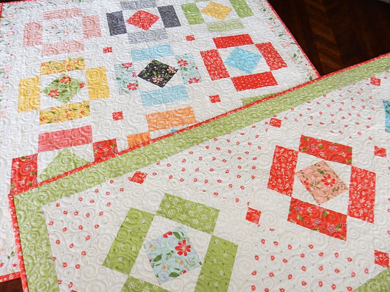 Simply charming runner and topper | Simply Charming Charm Pack Runner & Table Topper Quilt Pattern by popular US quilting blog, A Quilting Life: image of a finished Simply Charming table runner and topper.