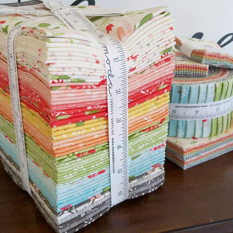 Summer Sweet Fabric Bundle | Gelato Medallion Quilt Pattern by popular US quilting blog, A Quilting Life: image of a Summer Sweet fabric bundle tied up with a Moda measuring tape.