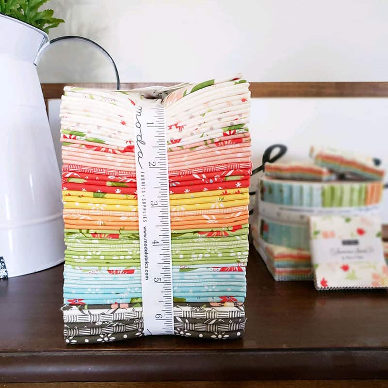 Summer Sweet Fabric Bundle | Introducing Summer Sweet Fabric by Sherri & Chelsi by popular US quilting blog, A Quilting Life: image of a bundle of Summer Sweet fabric tied up with a Moda measuring tape.

