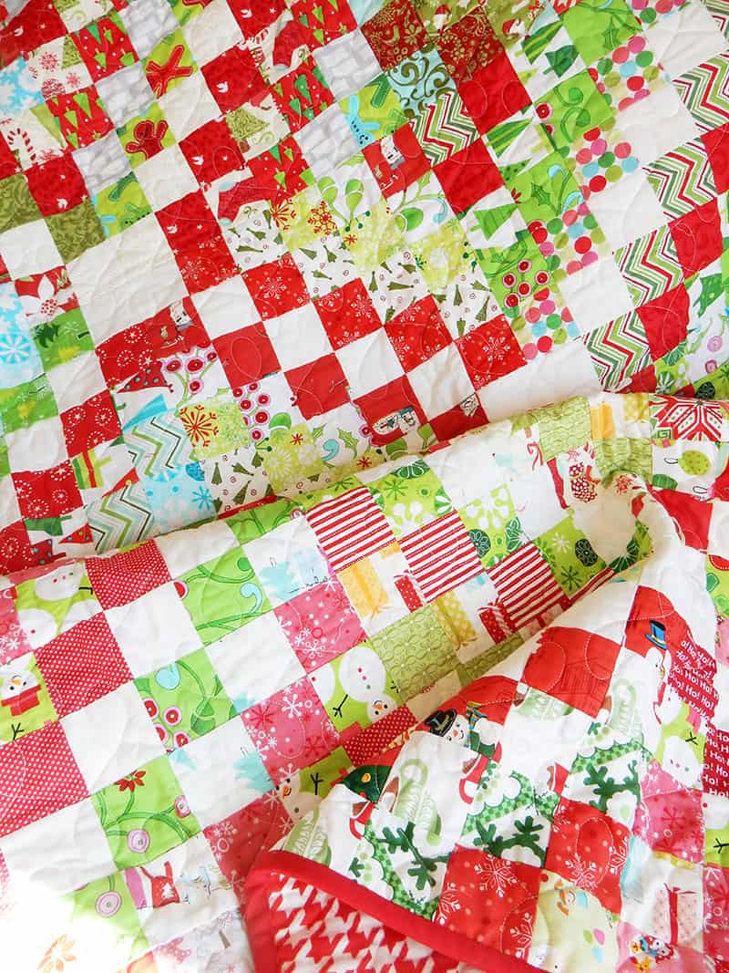 Best Tips for Storing Christmas Quilts and Decor Featured by Top US Quilting Blog, A Quilting Life: image of scrappy trip around the world quilt in Christmas fabrics