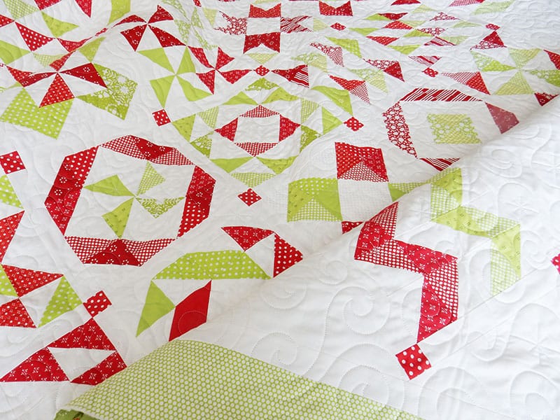 red and green half-square triangle quilt | 2019 Block of the Month Finishing by popular Utah quilting blog, A Quilting Life: image of a red and green half square triangle quilt. 