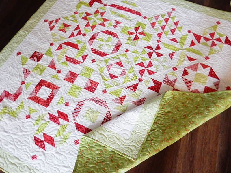 red and green half-square triangle quilt | 2019 Block of the Month Finishing by popular Utah quilting blog, A Quilting Life: image of a red and green half-square triangle quilt.
