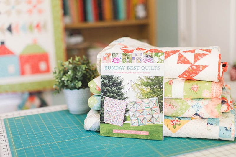 Sunday Best Quilts Sampler Finishing featured by Top US Quilting Blog, A Quilting Life: image of Sunday Best Quilts book and stack of quilts