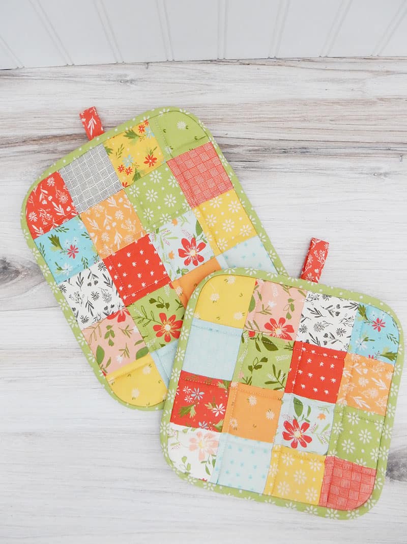 How to Make a Quilted Potholder featured by Top US Quilting Blog, A Quilting Life: image of patchwork potholders.