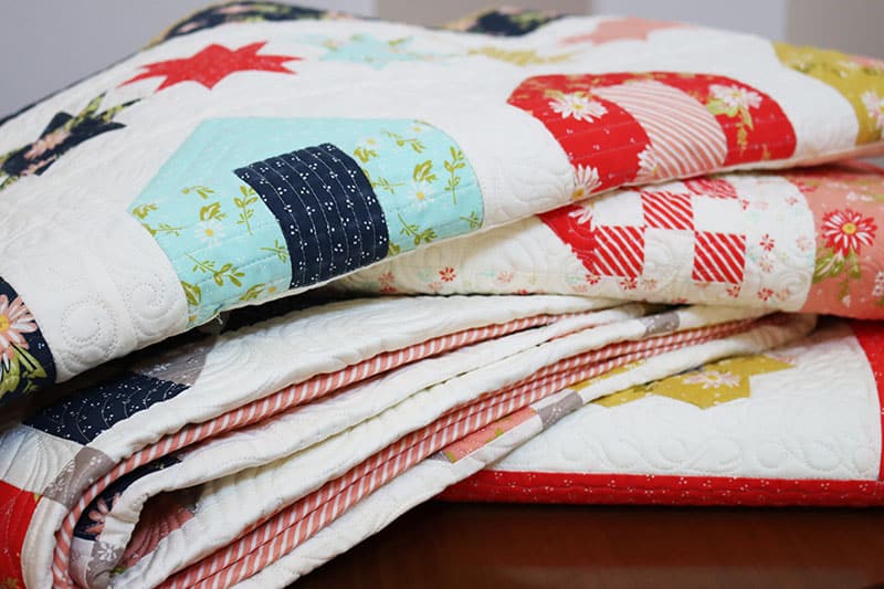 Beach House Row Quilt featured by Top US Quilting Blog, A Quilting Life: image of stack of quilts
