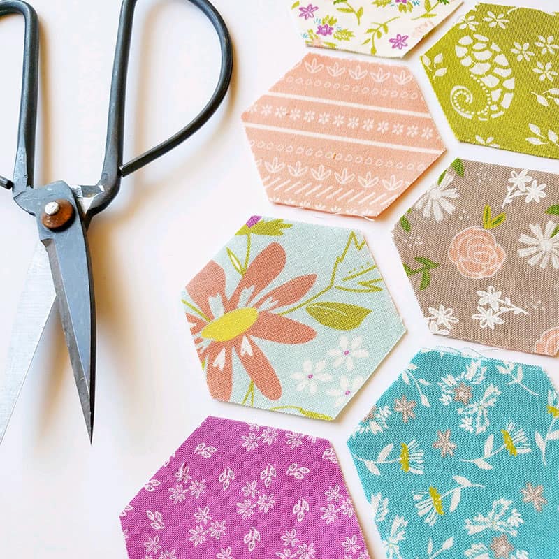 Saturday Seven 161 featured by Top US Quilting Blog, A Quilting Life: image of hexagon fabrics and scissors