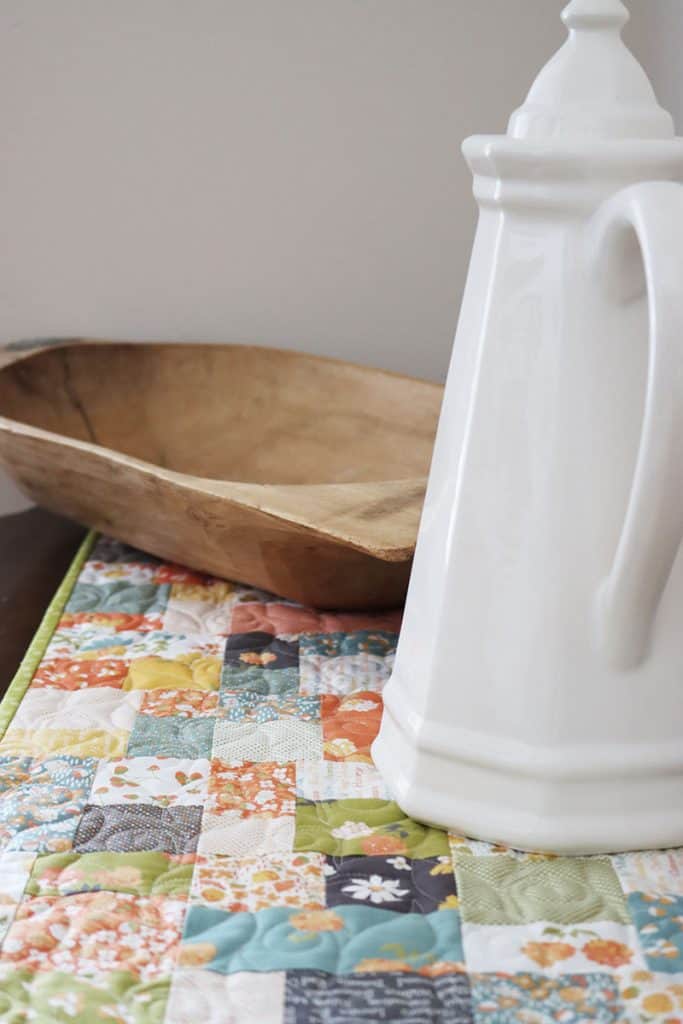 Saturday Seven 197 featured by Top US Quilt Blog, A Quilting Life: image of quilted table runner, antique dough bowl, and pitcher