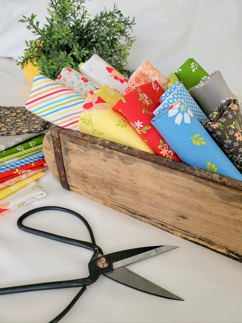 Spring fabrics in a wooden box with antique scissors