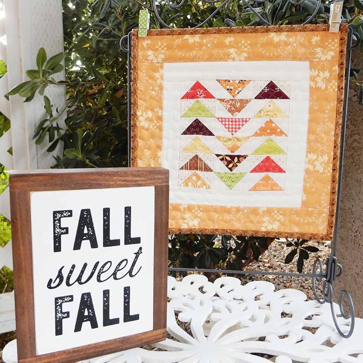 Fall Sweet Fall Sign with small quilt mini on a table stand.