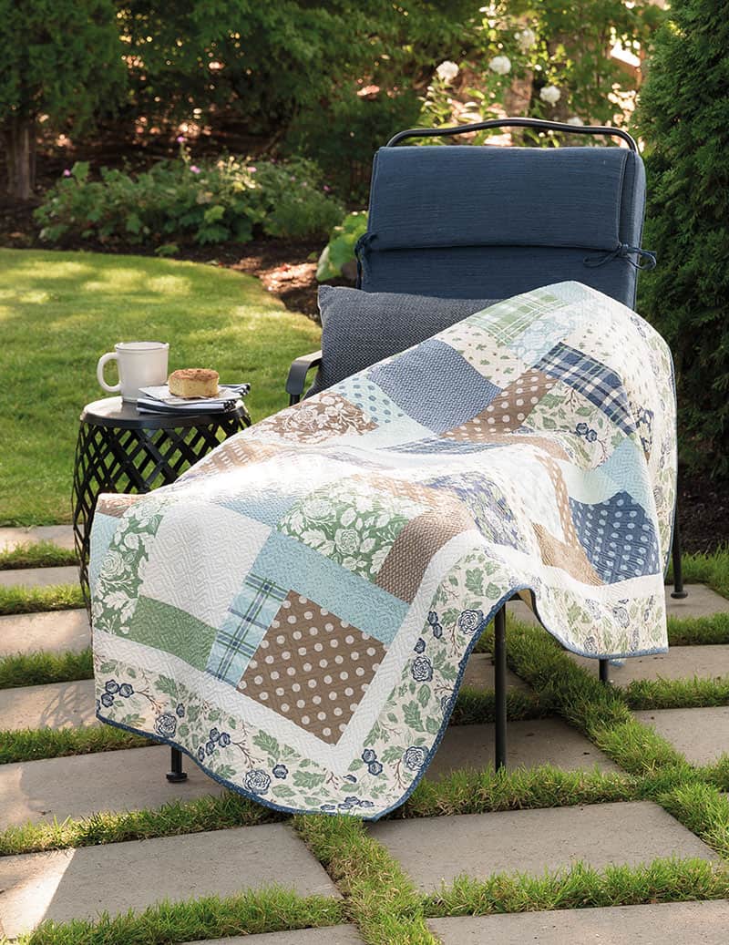 Patchwork quilt in blues, greens, and tan floral and print fabrics