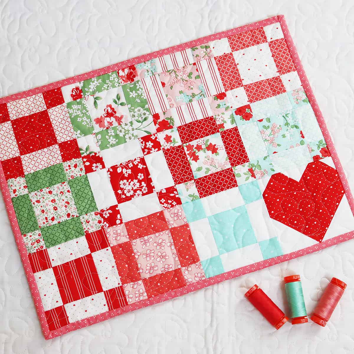 Patchwork quilted table mat with heart block.