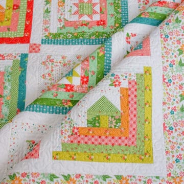 Log cabin quilt with house, star, and heart centers in bright fabrics