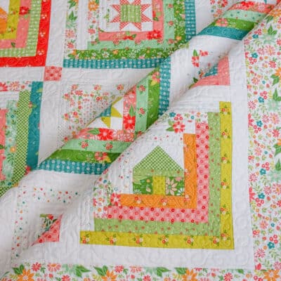 Log cabin quilt with house, star, and heart centers in bright fabrics