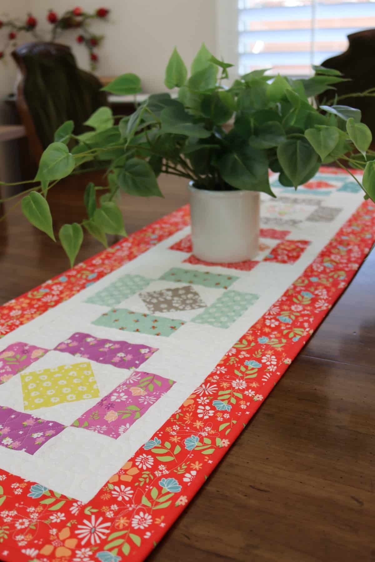 Quilted table runner in Laguna Sunrise fabrics by Sherri & Chelsi for Moda fabrics.