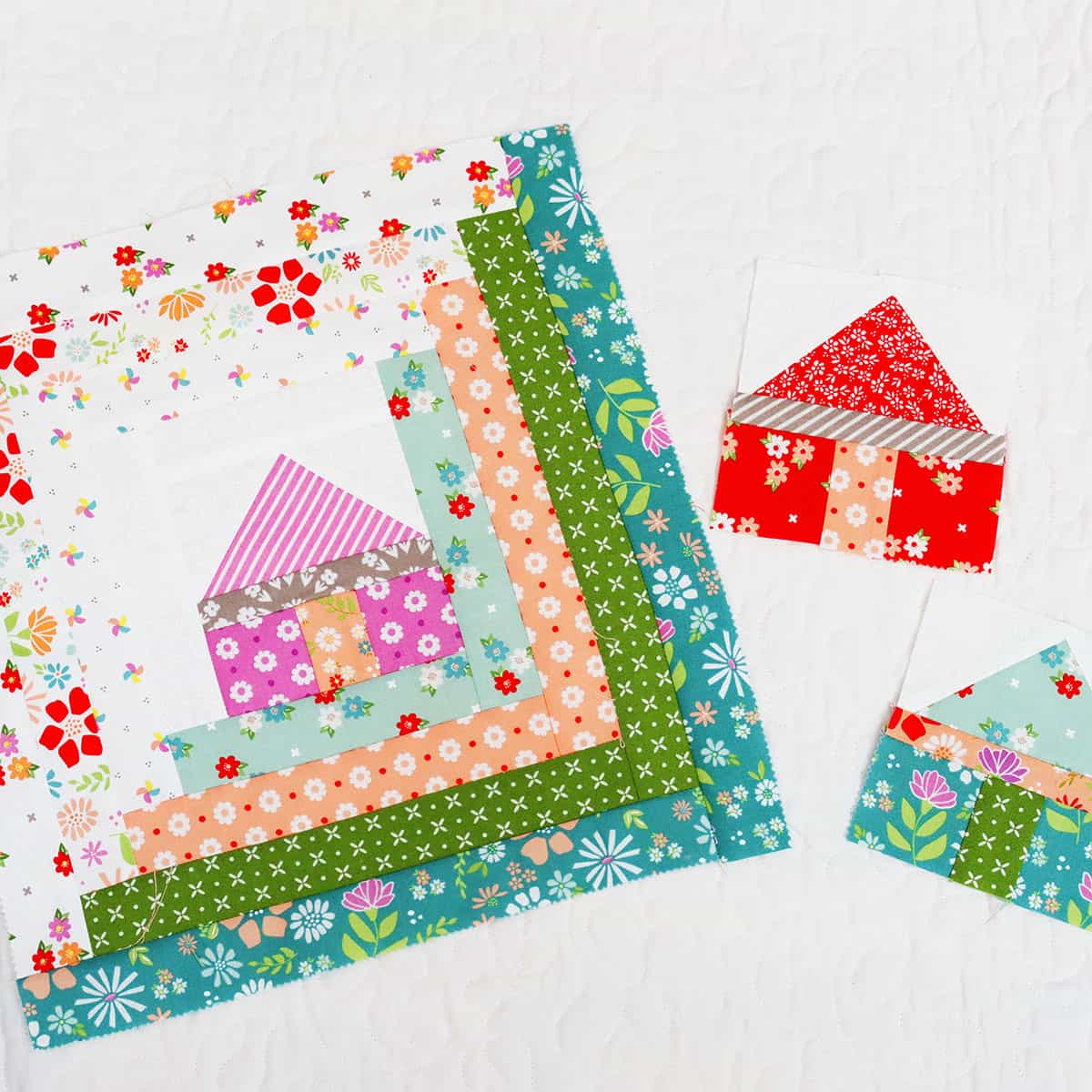Log cabin quilt block with house center and small house blocks.