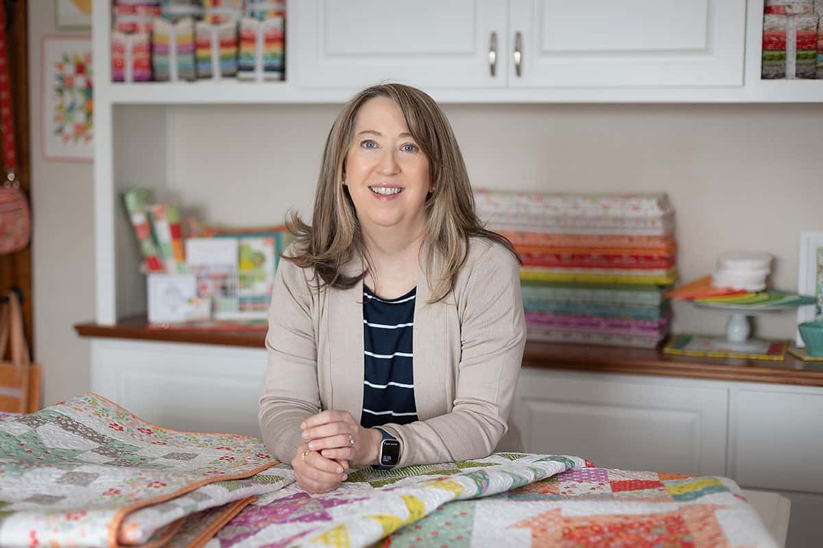 Sherri McConnell of A Quilting Life in her studio with quilts and fabrics