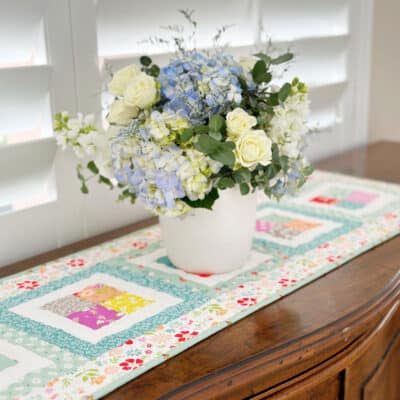 Scrappy quilted Table runner with floral arrangement