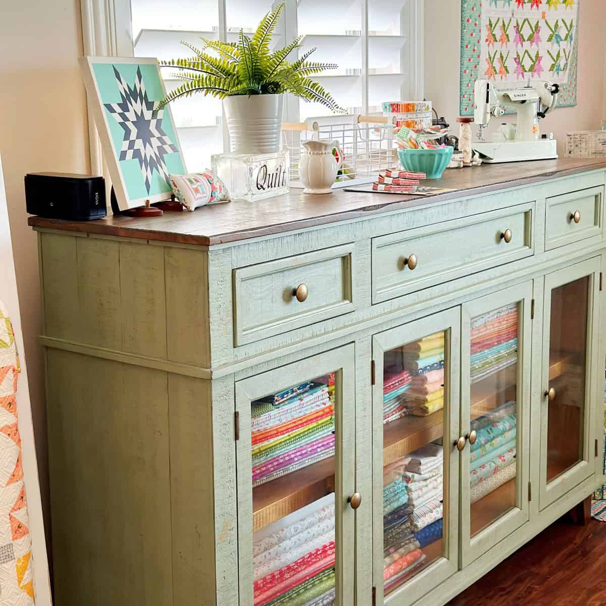 Cabinet with fabrics and sewing notions in the A Quilting Life Studio