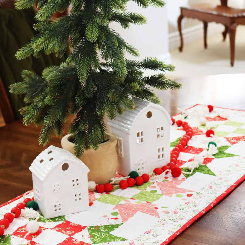 Patchwork Table Runner in Christmas fabrics with tree and white ceramic houses