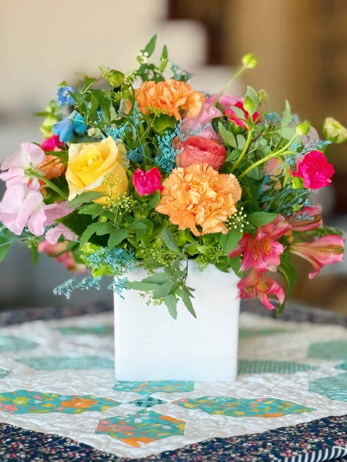 Spring floral bouquet on a quilted table topper by Sherri from A Quilting Life