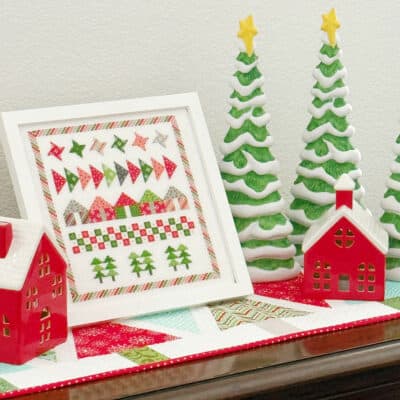 Ceramic trees and houses with cross stitch on tree table runner from A Quilting Life